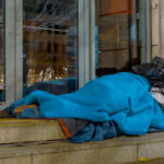 Stock image of homeless person sleeping in shop doorway.